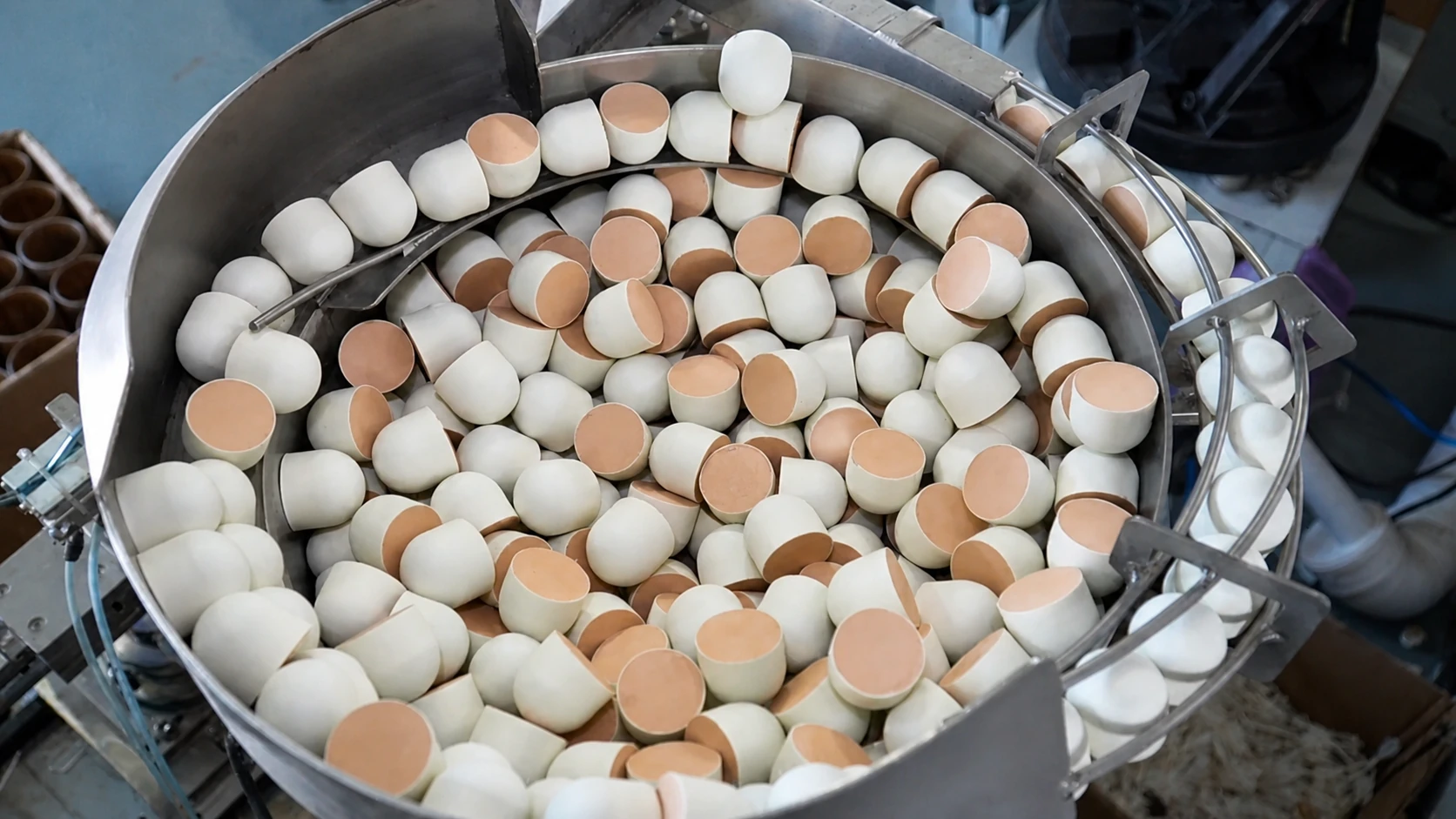 Natural cork bases moving through a factory feeding bowl